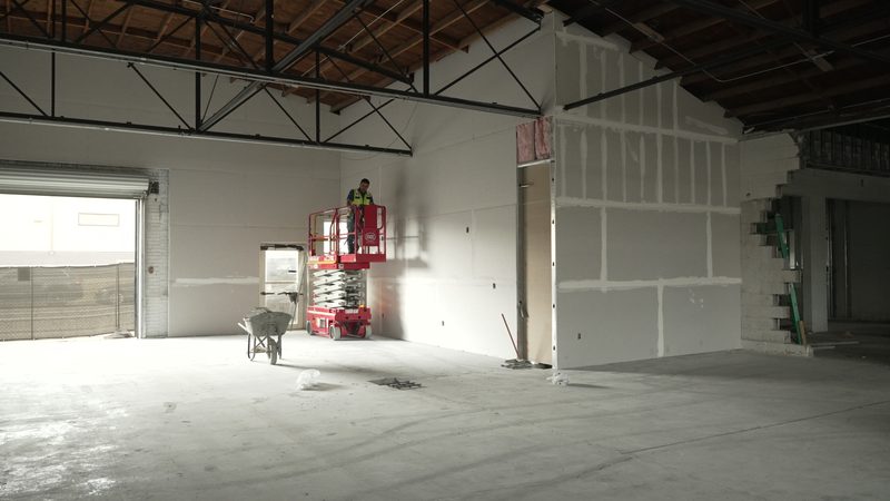 Interior build-out with new drywall and a scissor lift at work
