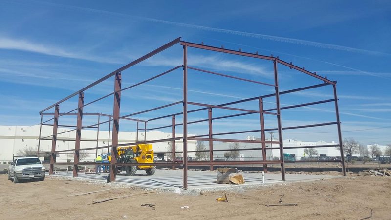 Steel building frame going up on a concrete slab, built by ARM